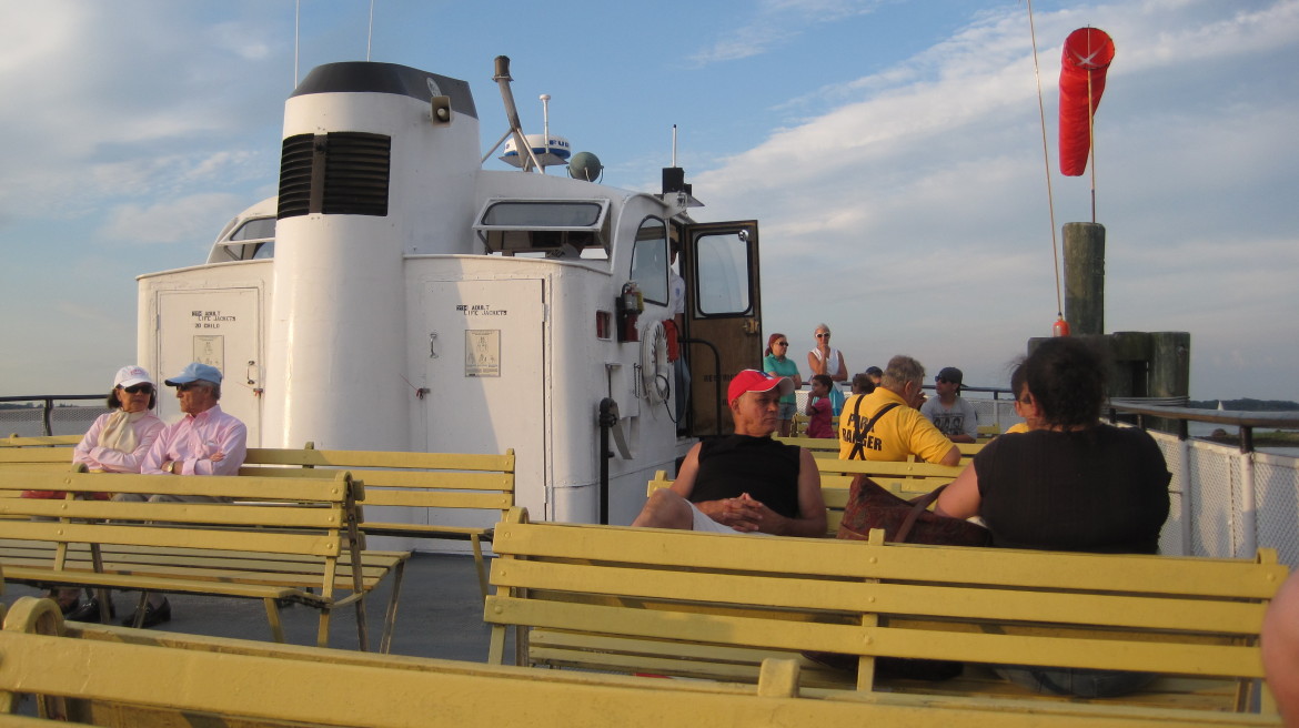 A Park Ranger, identified by his yellow shirt, rides the Island Beach Ferry.