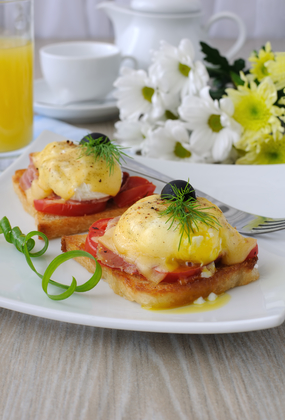 Eggs Benedict with ham and tomato on toast with cheese