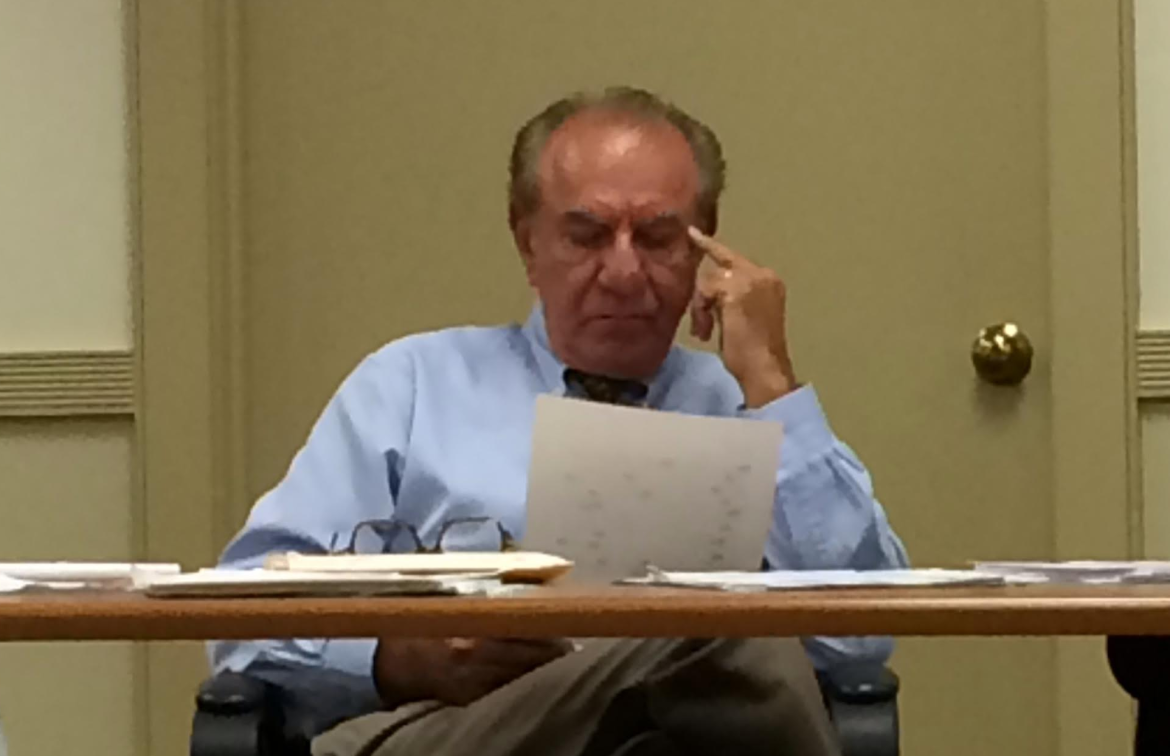 Mr. Webber reading a redacted during one of the publi hearings on John Yoon's termination. 