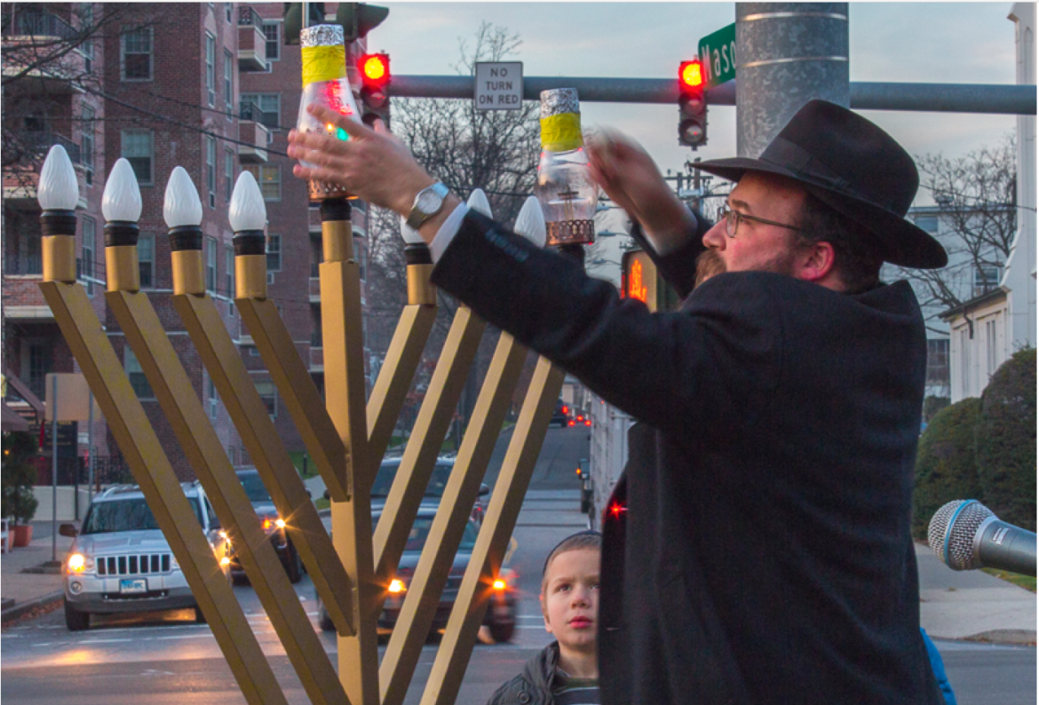  Rabbi Yossi Deren illuminates the menorah