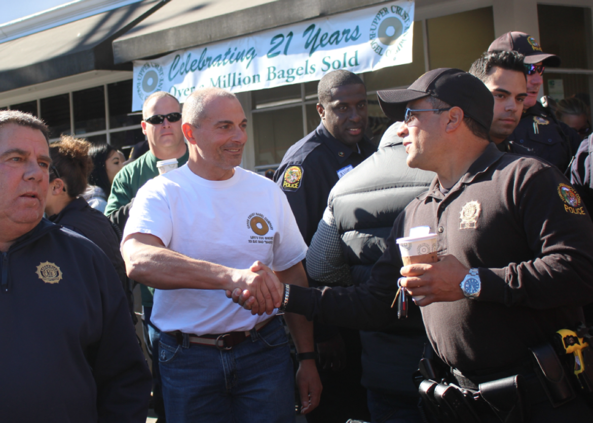 Upper Crust Bagel Co owner Robert Guerrieri shakes hands with officer Carlos Franco at the Coffee with a Cop event on Oct. 18, 2105. Credit: Leslie Yager