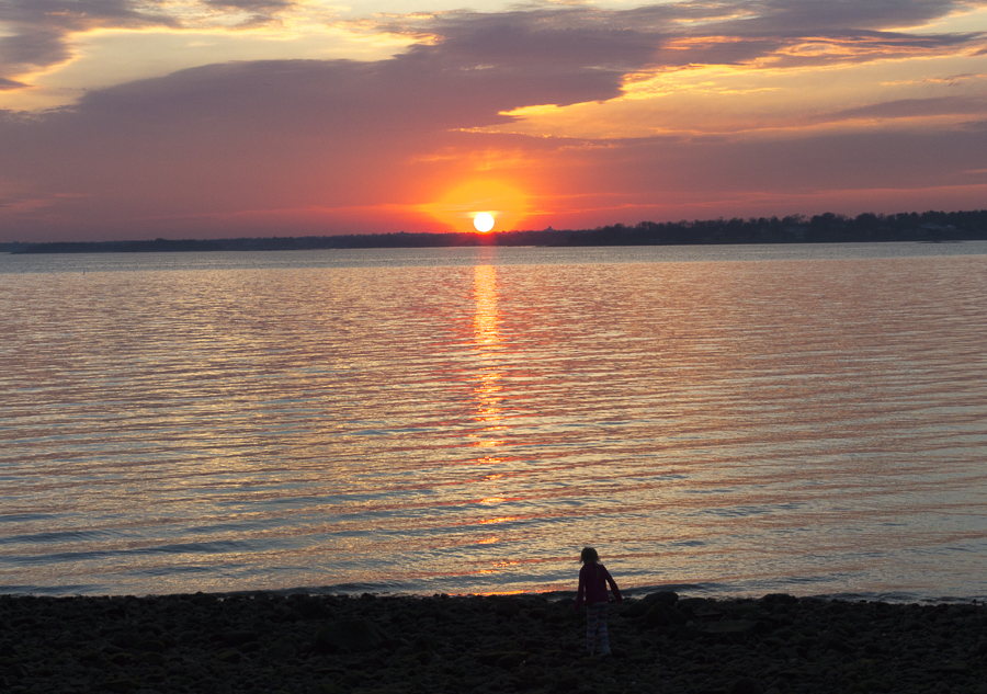 A luminous sunset with a young girl in its shadow. Credit: Karen Sheer
