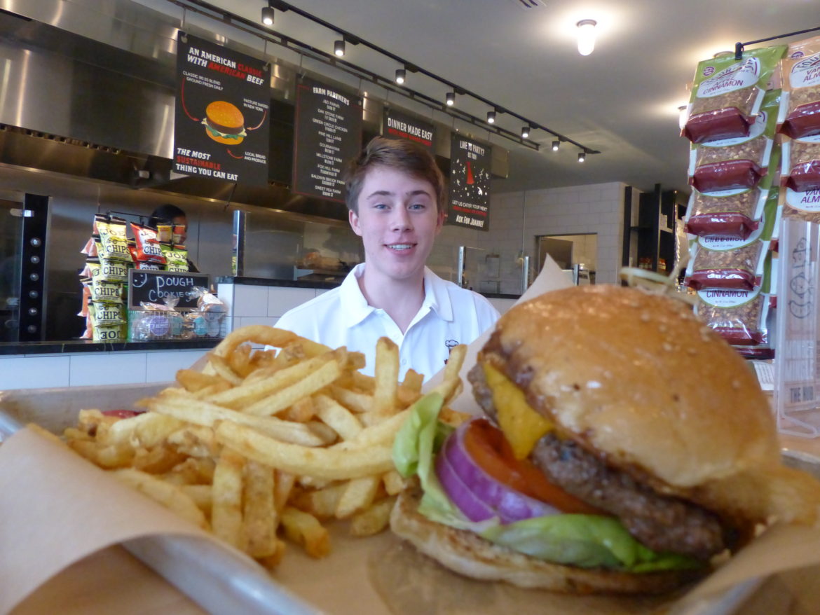     Drew happily posing for the photo before digging into the "Classic Burger". Credit: Kai Sherwin