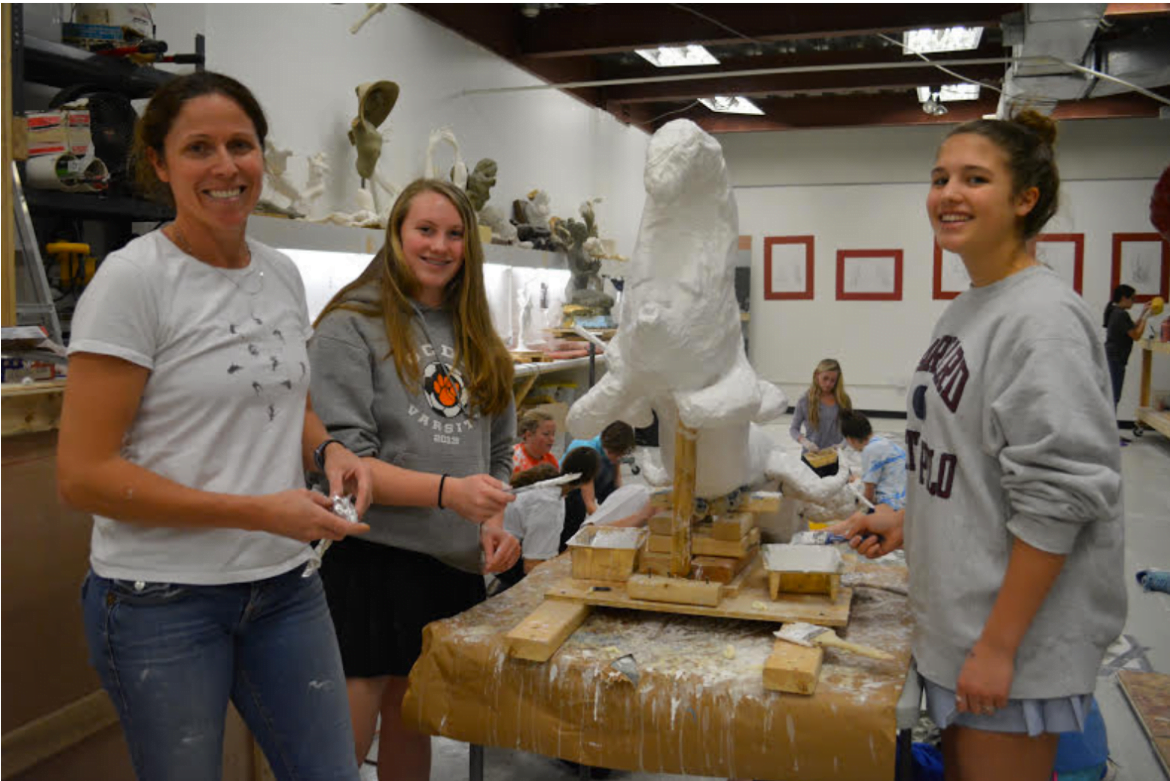 Artist Paige Bradley and GCDS students Britney Parkinson and Sofia Giannuzzi in front of the caterpillar creation