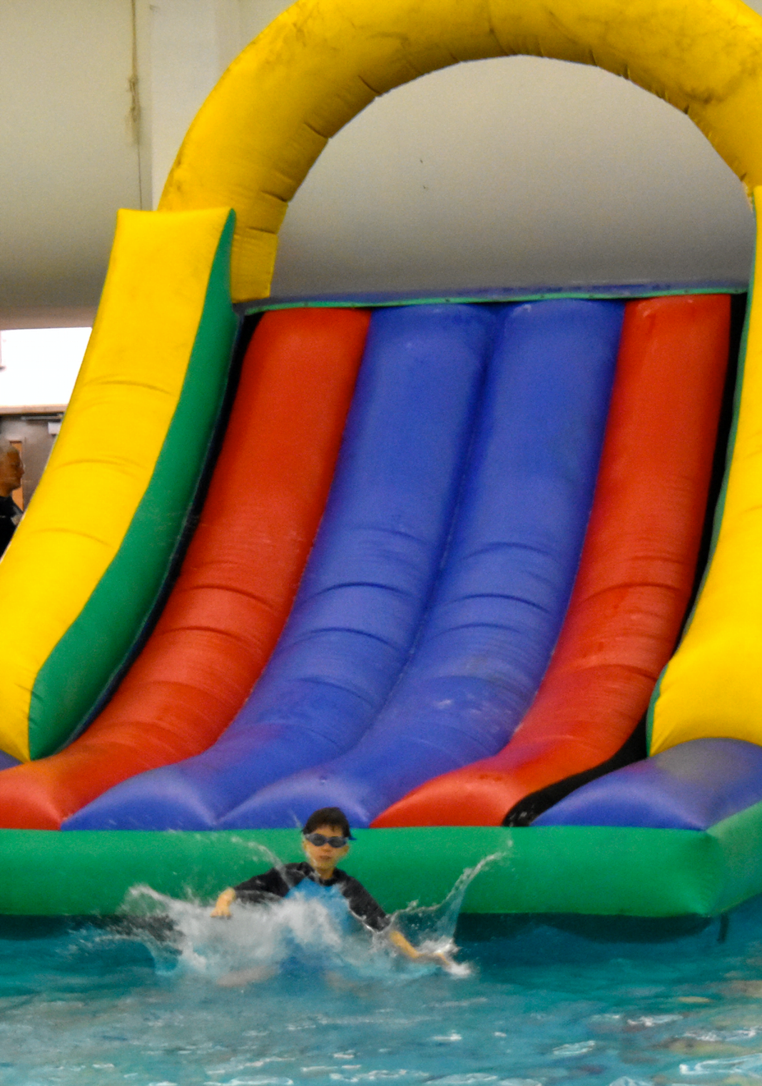 Scout makes a splash of the giant inflatable slide at the YMCA “Scout Night” event in Greenwich. Photo credit: Heather Brown 
