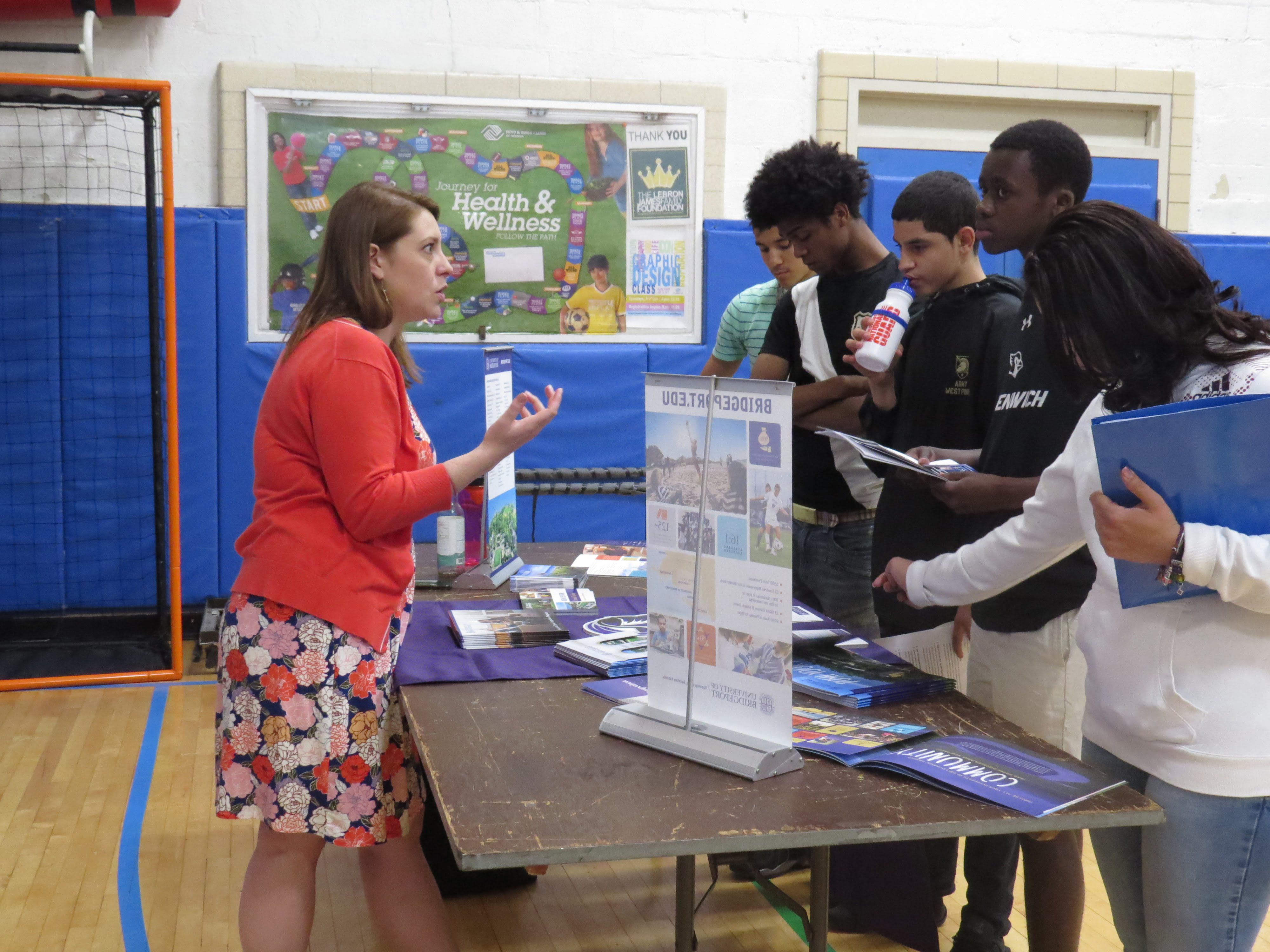 A group of high school students speak with a representative from the University of Bridgeport. May 23, 2017. Photo: Devon Bedoya