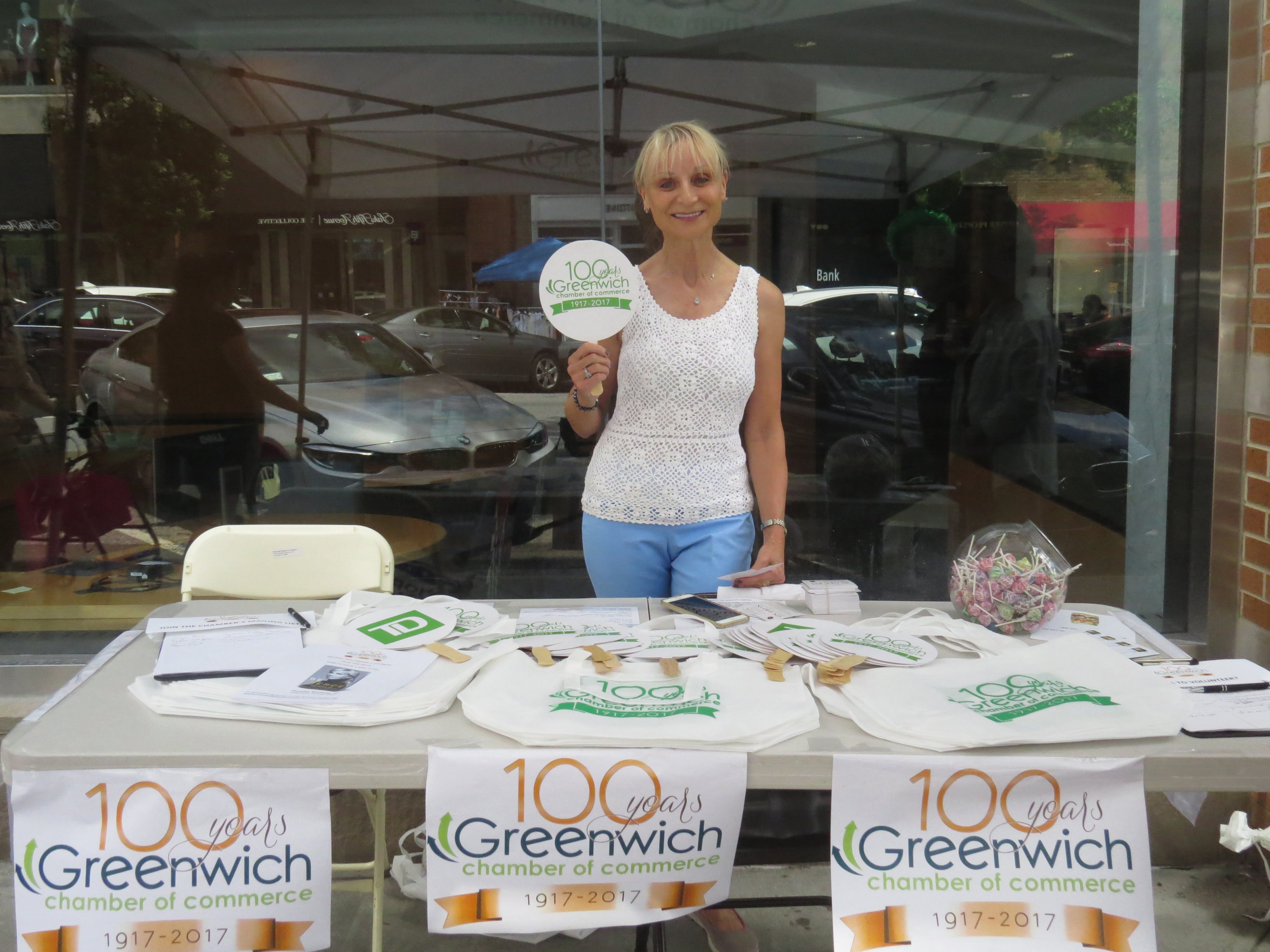Marcia O'Kane, CEO of Greenwich Chamber of Commerce, stands outside TD Bank to give out fans for shoppers to keep cool in the heat. July 15, 2017. Photo: Devon Bedoya 