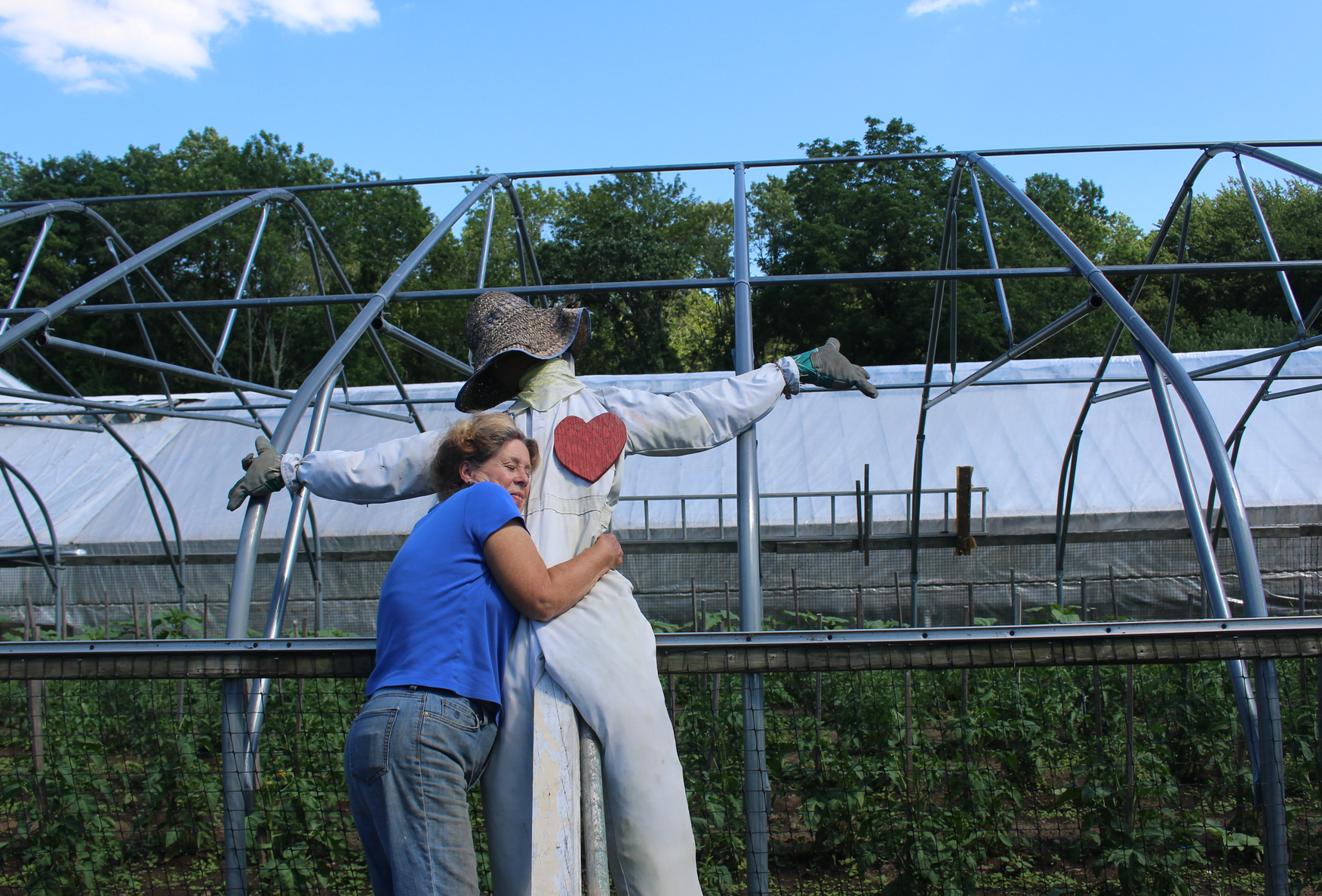 At the end of a long day at the farm stand on Sunday, Kathy Augustin gives her favorite scarecrow a hug. July 9, 2017 Photo: Leslie Yager