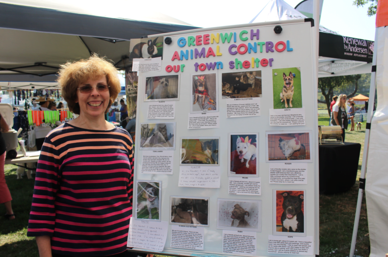 Linda Bruno with a poster of all the dogs available for adoption from Greenwich Animal Control on North Street. Sept 17, 2017 Photo: Leslie Yager