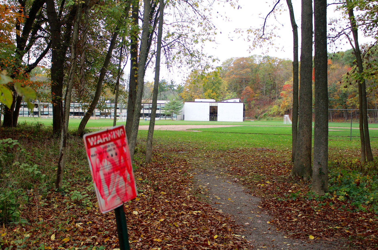 Pathway from the CMS fields to Orchard Street features a sign warning against ticks. Photo: Leslie Yager