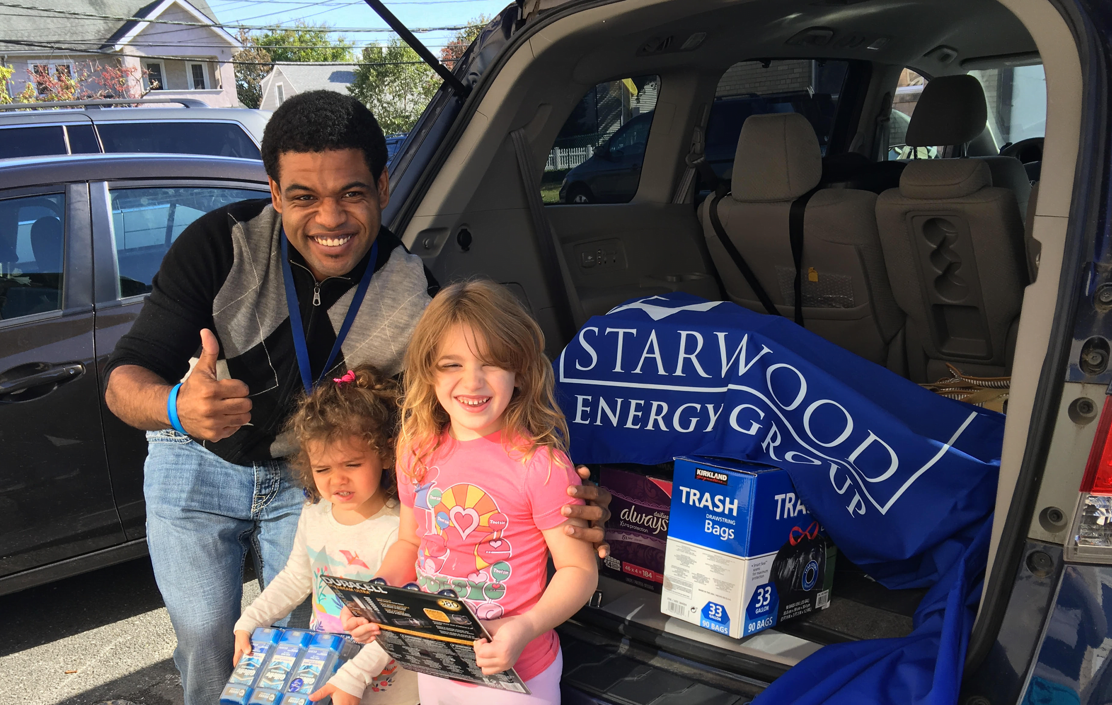Preschool Teacher Jordan Rose helps unload donations from the Starwood Energy Group with assistance from his students Marlowe Ingrassia and Victoria Toni. 