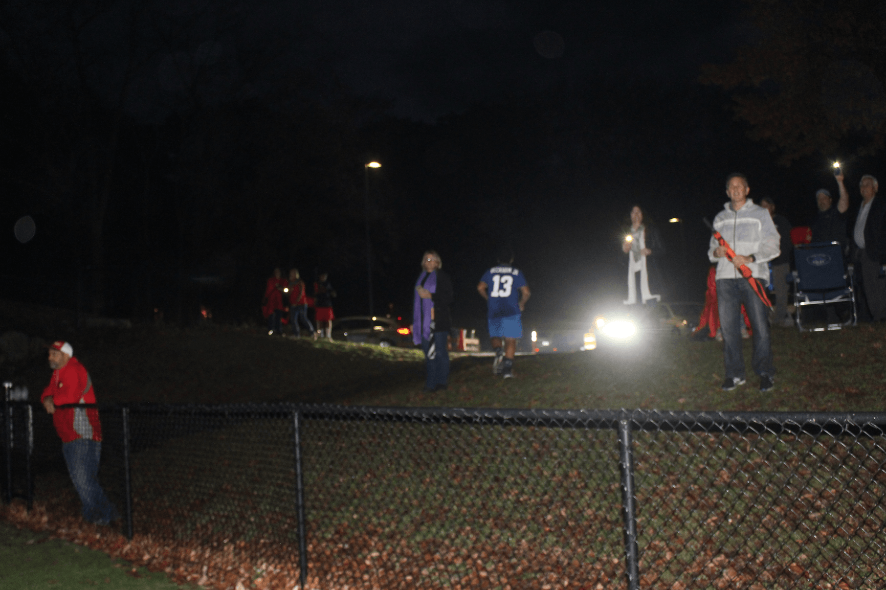 Headlights of cars shone from the parking lot and parents held up flashlights as the JV football game proceeded on field 7 in semi-darkness on Nov 6, 2017, the first day after daylight savings time and new dismissal times converged Photo: Leslie Yager