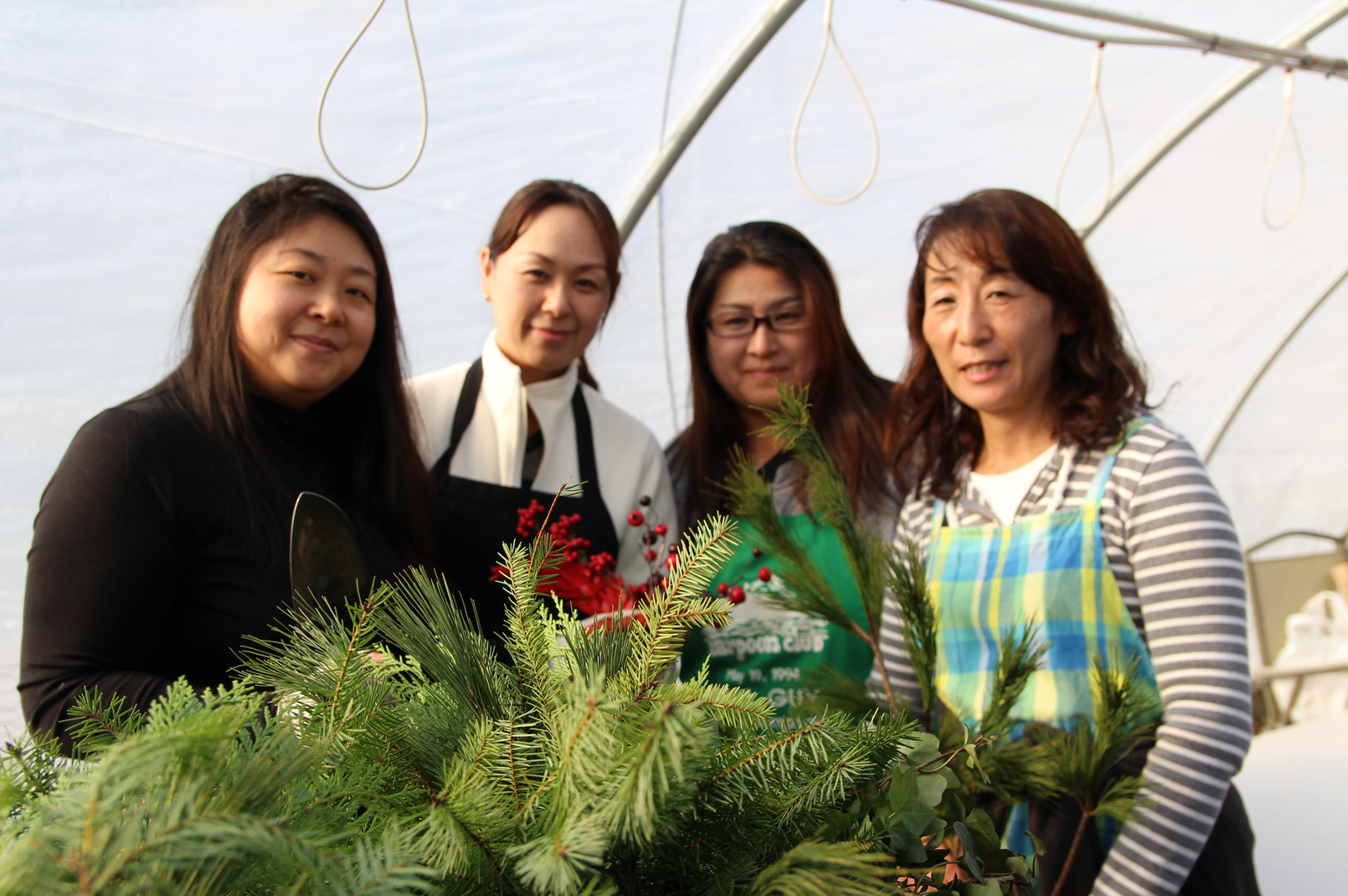 About 30 Japanese women gathered with Mary Hull and Sally Davies of Greenwich Green & Clean at Sam Bridge Nursery & Greenhouses on North Street to arrange holiday baskets of greenery. Photo: Leslie Yager