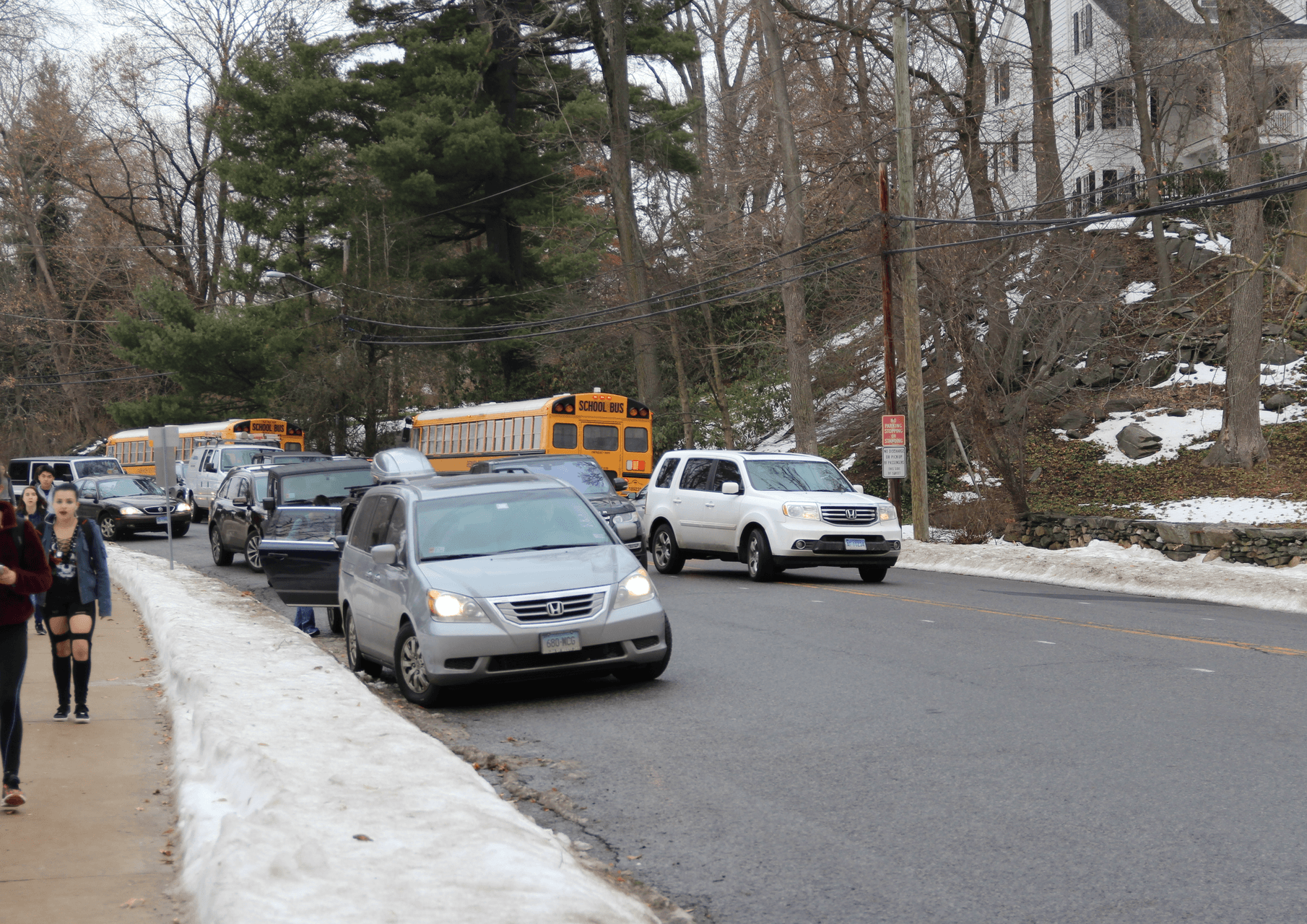Car crosses double yellow line around double parked cars to move from Hillside Rd toward East Putnam Ave at dismissal time. Jan 11, 2018 Photo: Leslie Yager