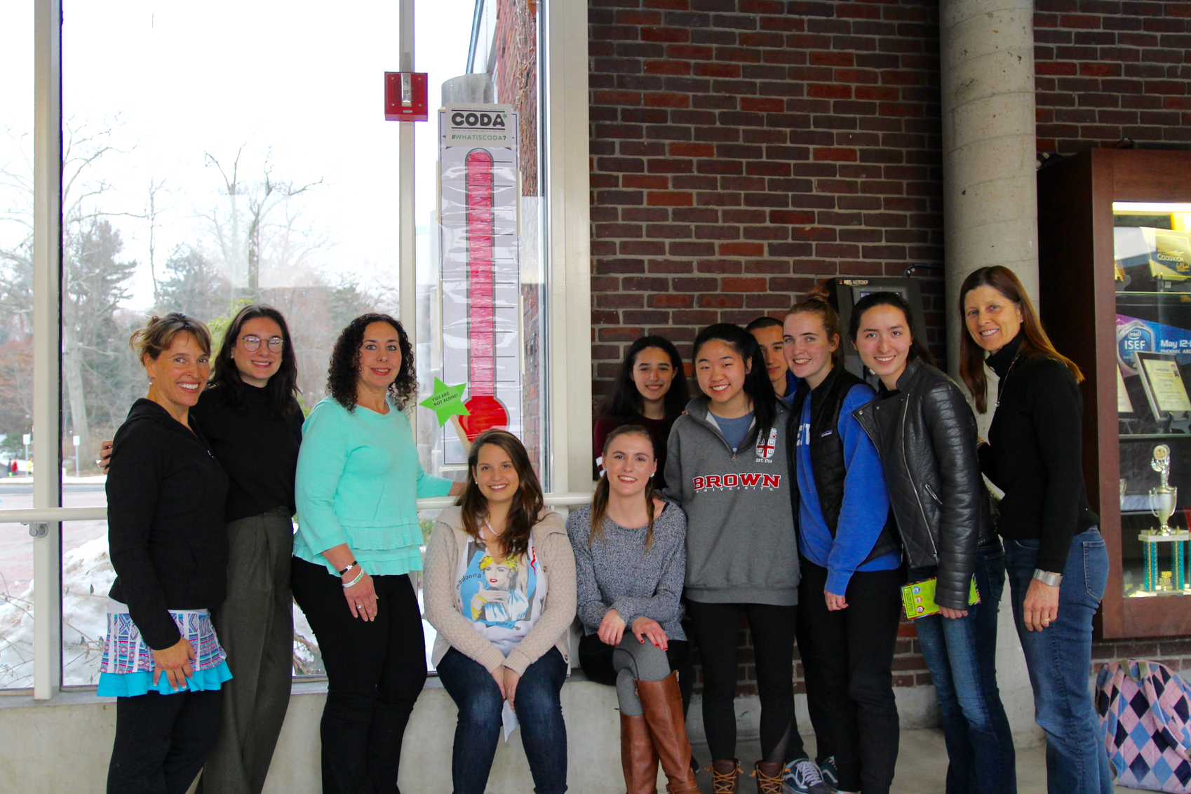 Outreach advisor Amy Badini, Rebecca Lehner from Fairco Greentree Recycling, The Harris Project founder Stephanie Marquesano, Jeanette Petit, Catherine Baumgarten, GHS Outreach Club's Rosanna Neri, Jamie Yee, Matthew Gesell, Claire Hacker, Monique Nikolov, and GHS health teacher Kathy Steiner standing by the "CODA thermometer" in the glass corridor at Greenwich High School. Jan 10, 2018 Photo: Leslie Yager