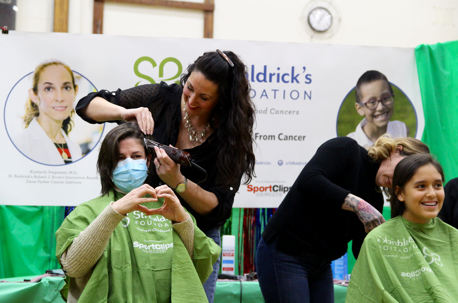 Heather Brown makes a heart as she prepares to be shaved to raise funds for St. Baldrick's Foundation. March 15, 2018 Photo: Leslie Yager