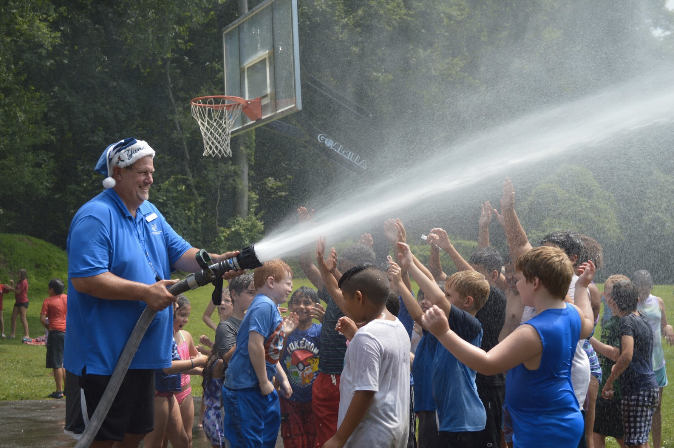 Program Director Don Palmer takes a turn spraying the campers. Photo by: Alex LaTrenta