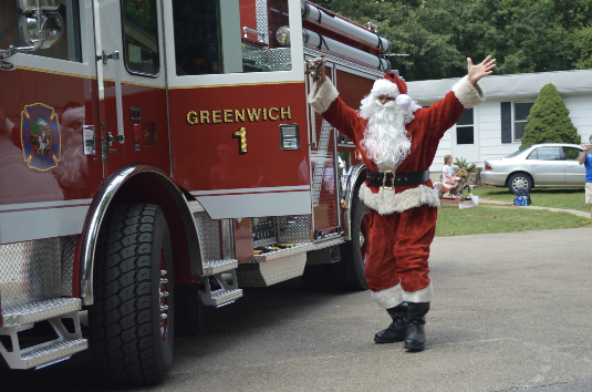 Santa climbs out his fire truck with a fistful of candy canes to greet Camp Simmons. Photo by: Alex LaTrenta