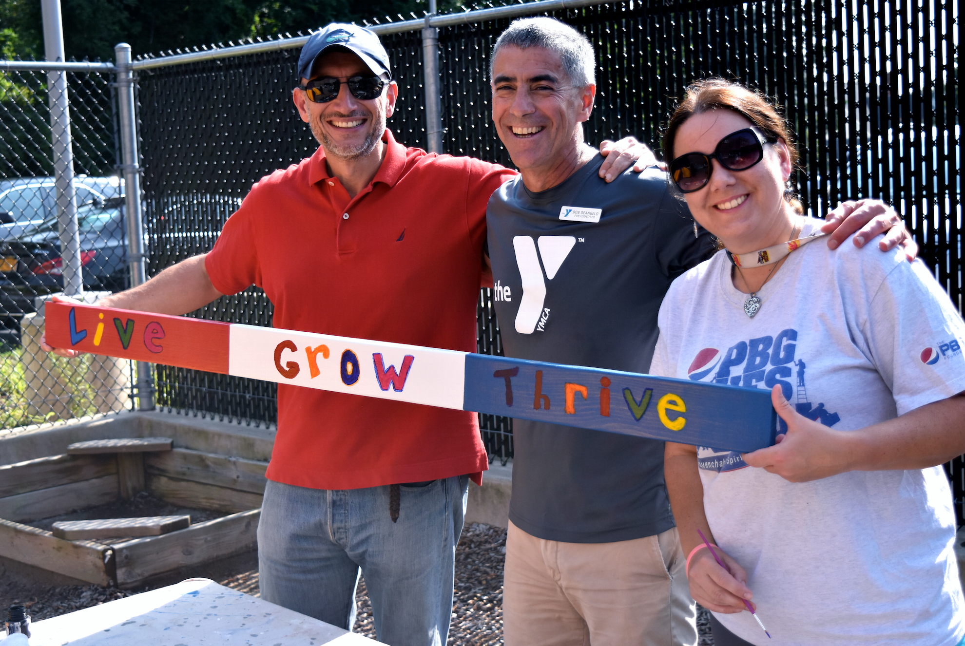 Bob DeAngelo showcases a painted sign with volunteers at the YMCA of Greenwich for PepsiCo's annual "Give Back Days" program.