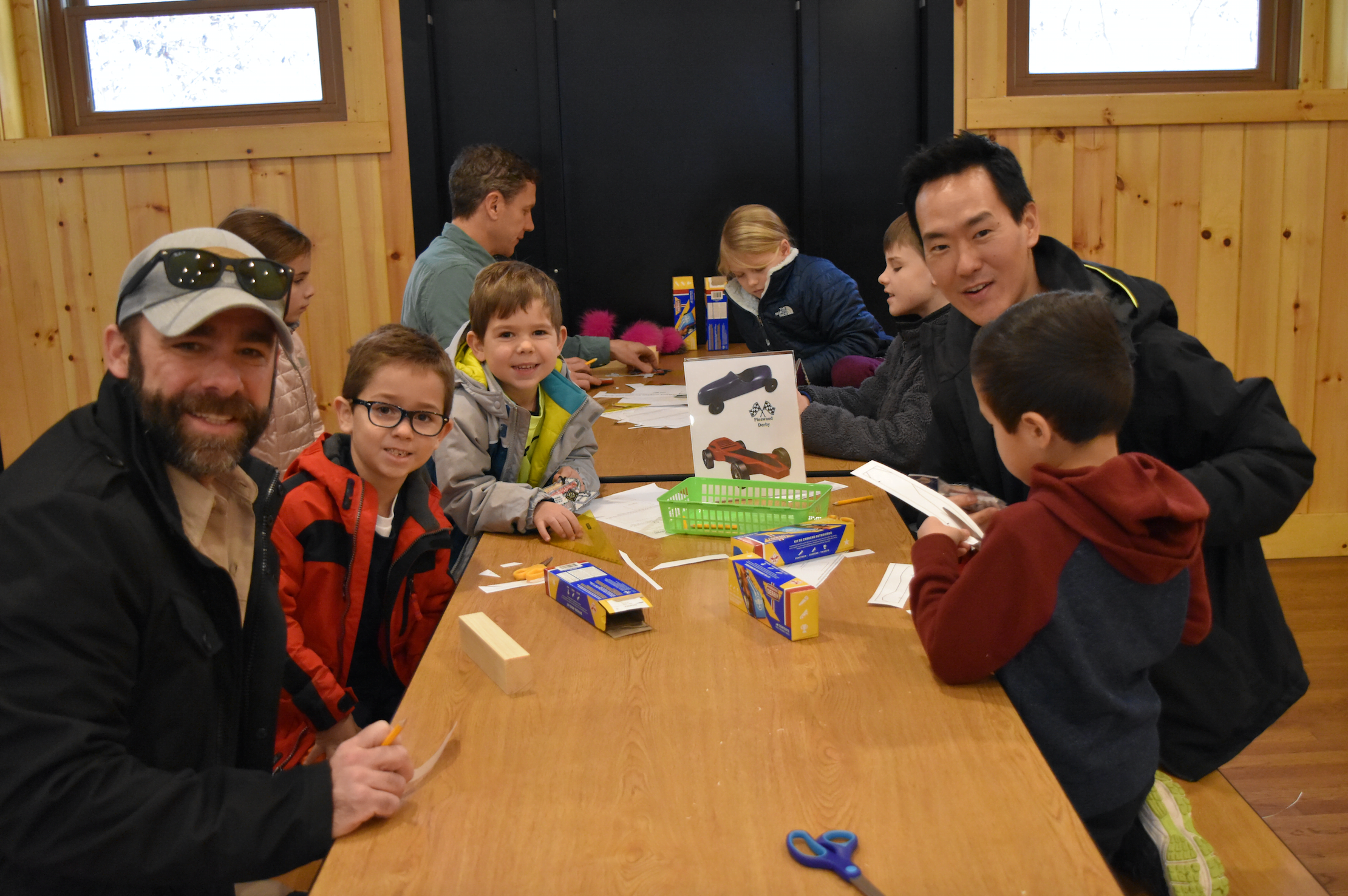  Cub Scouts with their families sketch designs on their pine block at the Greenwich Council, BSA annual Pinewood Derby Workshop at Seton Scout Reservation in Greenwich.