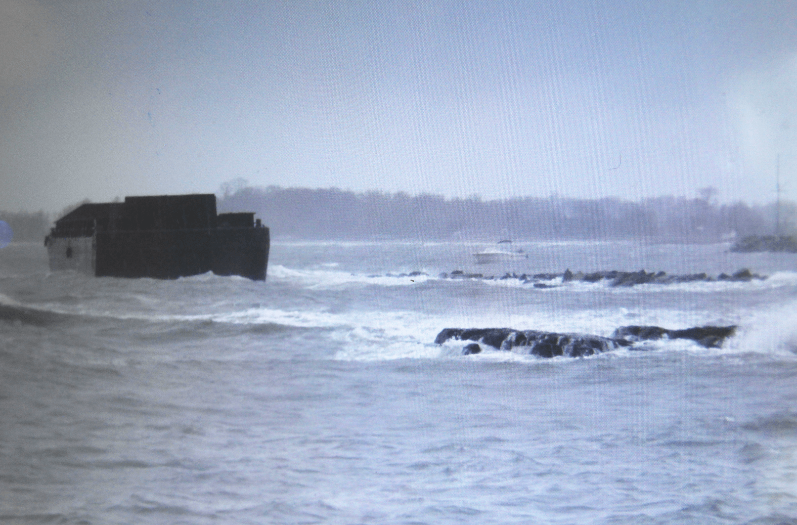 A barge that came loose from its mooring, drifted and got stuck on rocks at Rocky Point in 2014. Photo: Greenwich Harbor Master