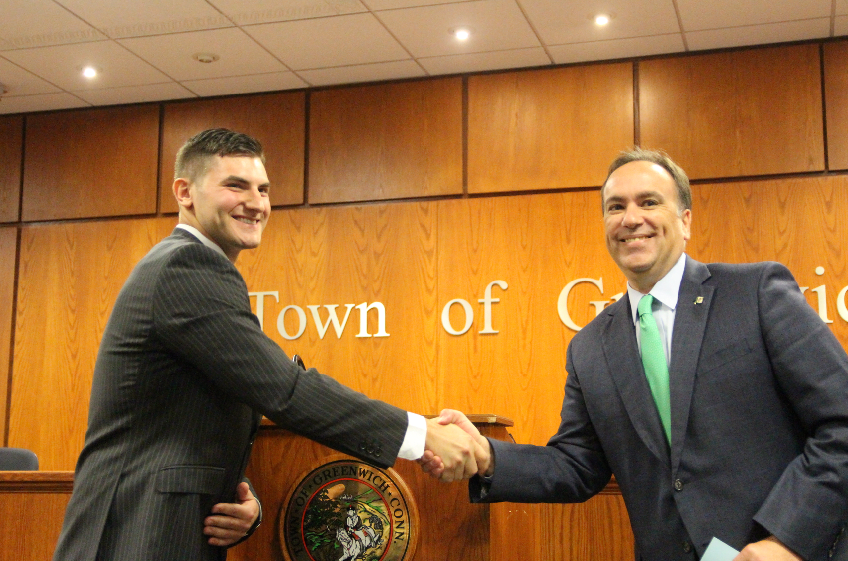 Newly sworn in Greenwich Police Officer Michael Bellairs II is congratulated by the Police Commissioner, First Selectman Peter Tesei. July 25, 2019 Photo: Leslie Yager