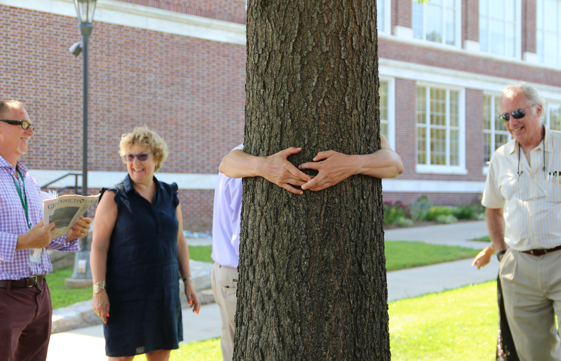 Town of Greenwich Superintendent of Parks & Trees Dr. Greg Kramer, executive Director of Greenwich Tree Conservancy JoAnn Messina and GTC Mark Greenwald look on as someone hugs the pin oak tree at Greenwich Town hall, Aug 15, 2019