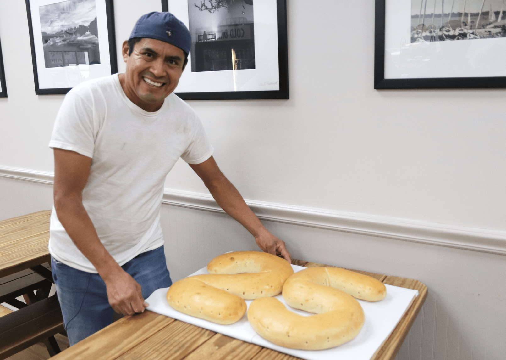 Ricardo Gomez, a baker at Upper Crust Bagel Co, with the giant bagels in honor of the eatery's 25 years in business. Dec 4, 2019 Photo: Leslie Yager