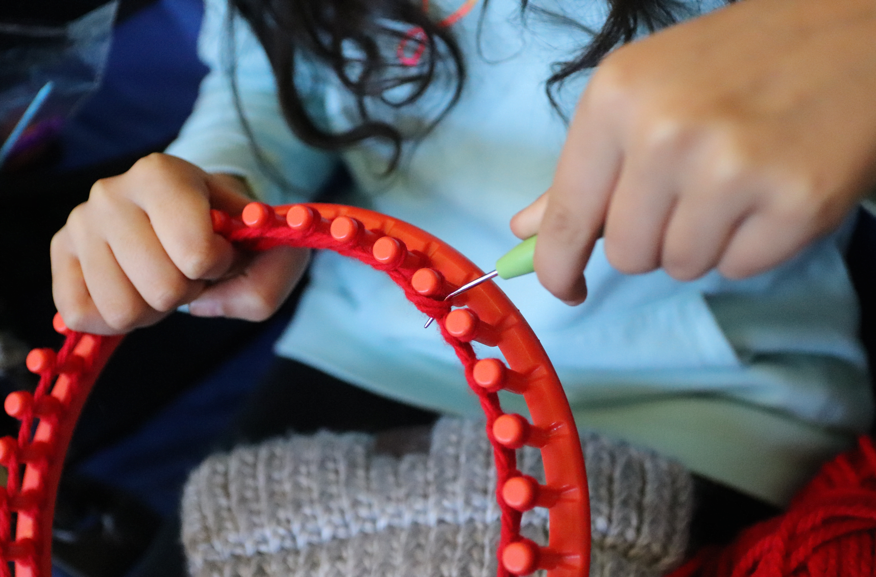 Katelyn Bae gets started on making a red hat using a circular loom. Feb 21, 2020 Photo: Leslie Yager