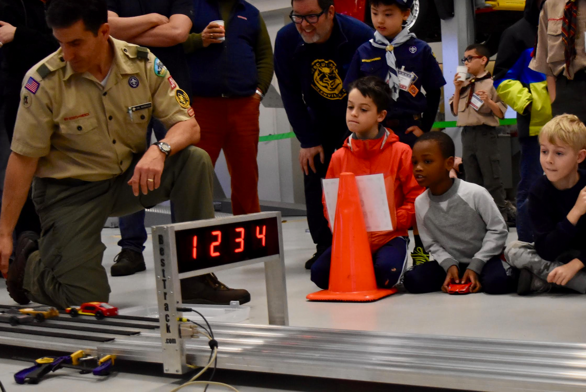  Cub Scouts and their parents watch the finish line at the 2019 Pinewood Derby Championship at Miller Motorcars. Adults will have their chance to race on March 7th at the Pinewood Derby Social.