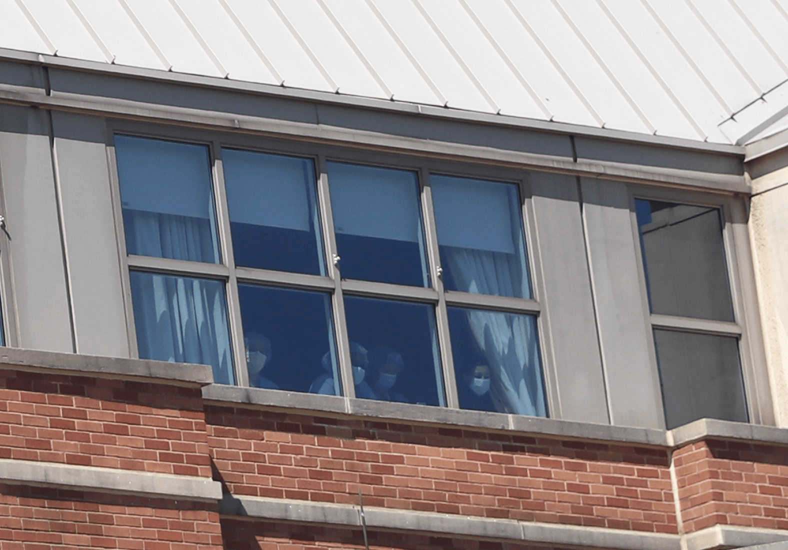 Staff who weren't outside the hospital peered down from a hospital window at the caravan of first responders. April 15, 2020 Photo: Leslie Yager