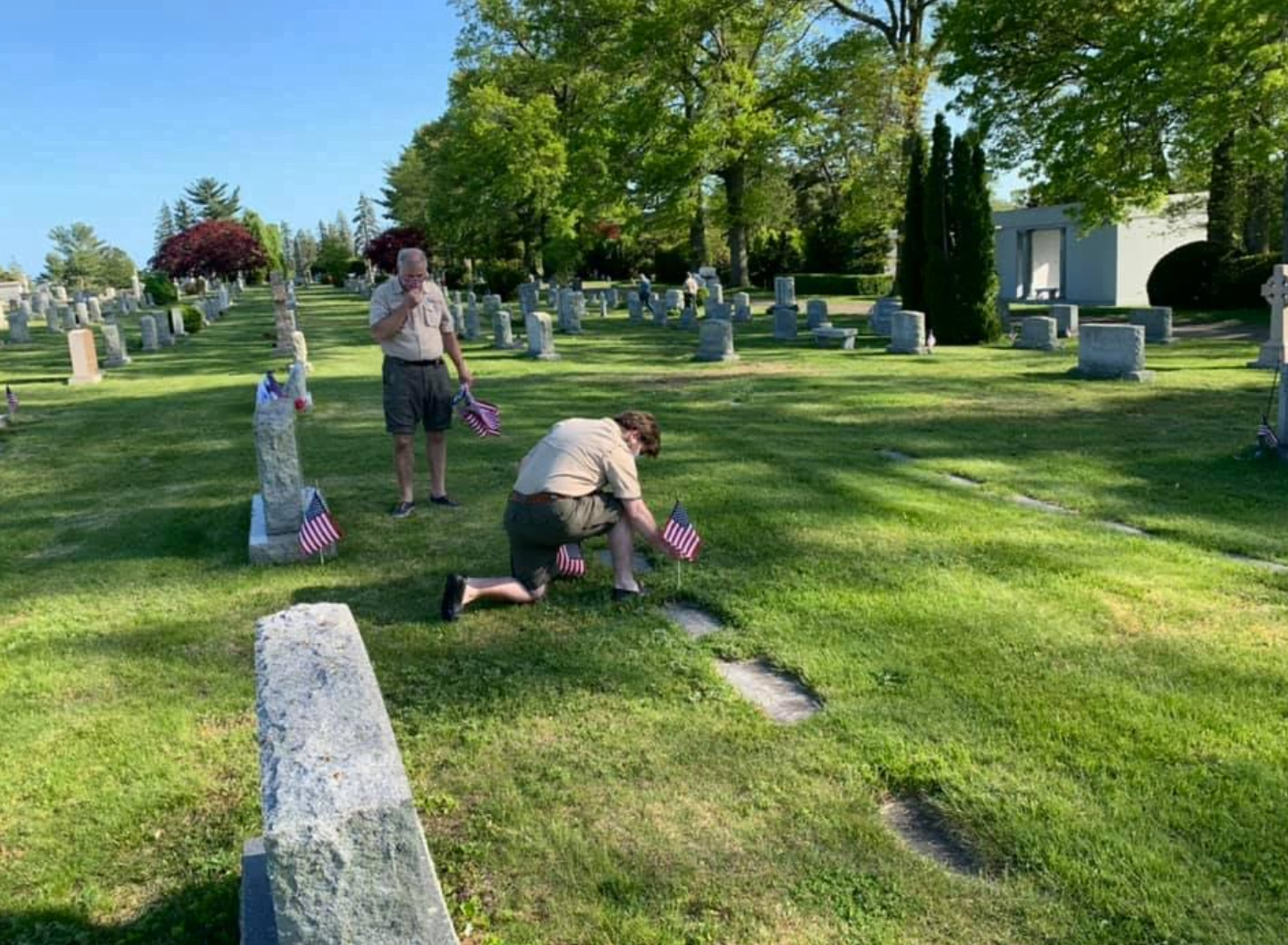 Troop 10, Eagle Scout, Ryan Hays locates a foot stone with a Veteran marker and places a flag in observance of Memorial Day.